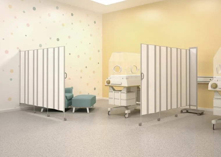 Dois biombos de PVC brancos separando leitos em uma enfermaria pediátrica