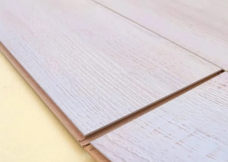 Réguas de piso laminado branco acinzentado encaixadas, vistas de perto